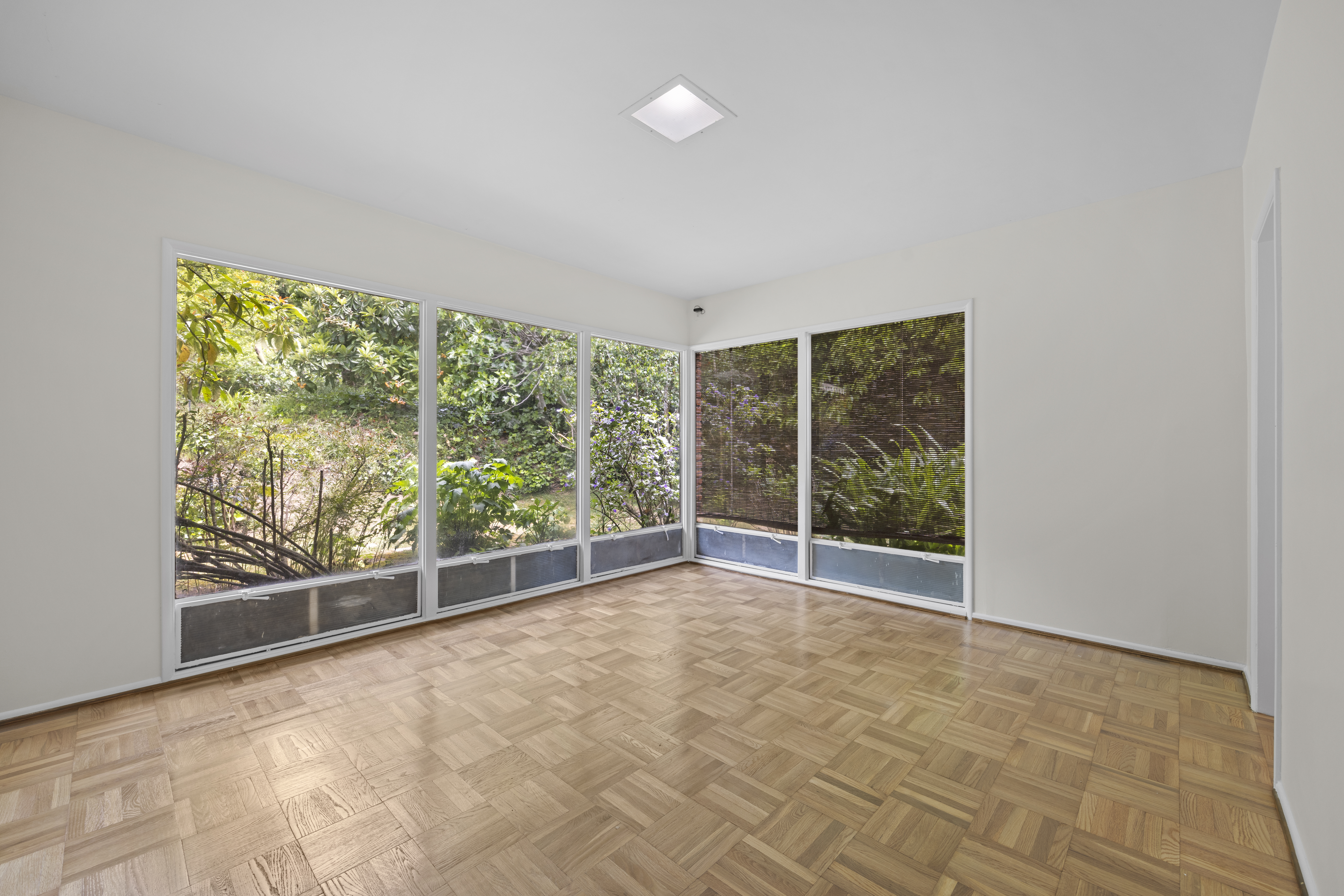 Empty room with corner windows, bright Southern California unit