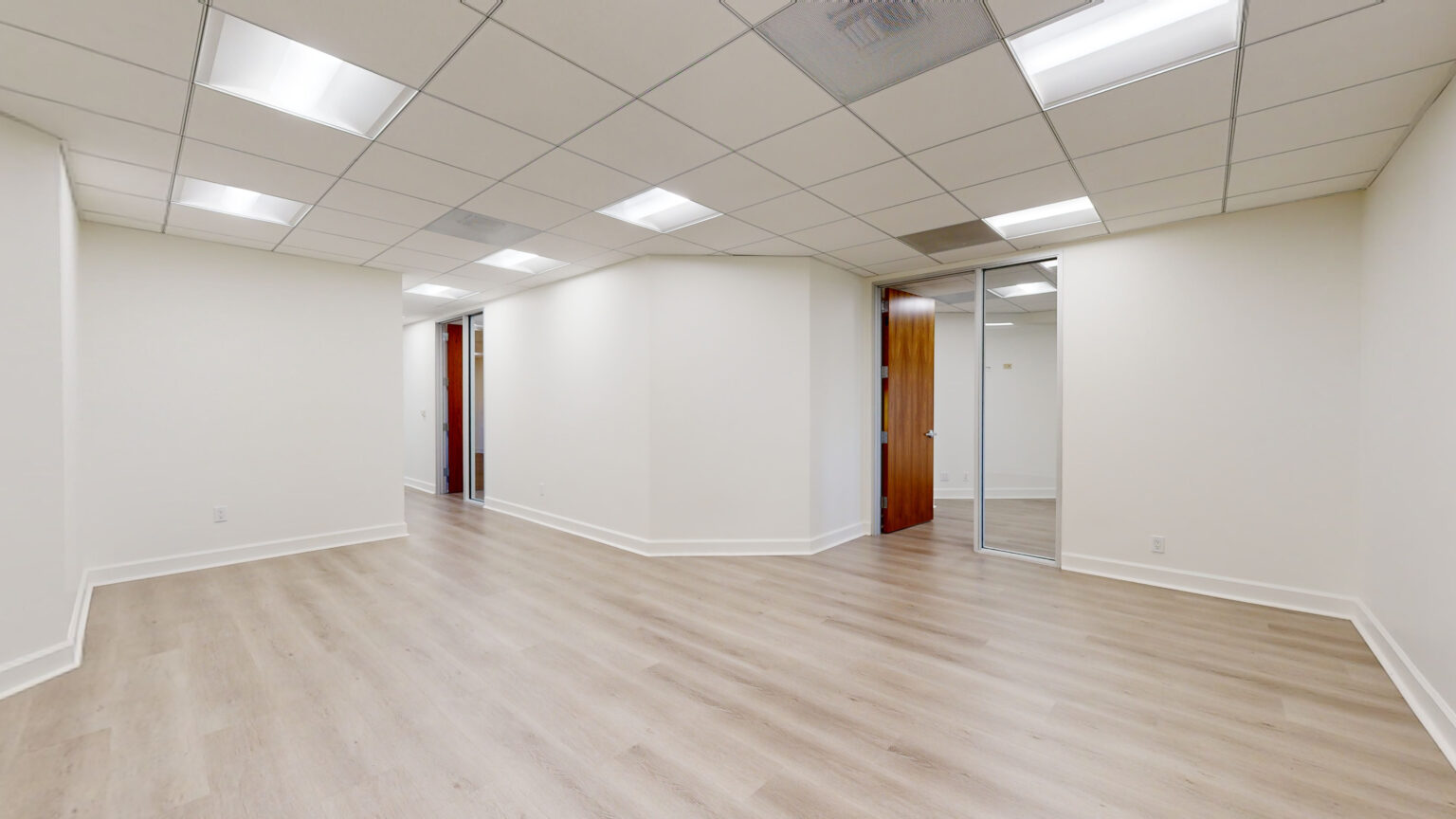 Another angle of empty office with bright lights and wood floor