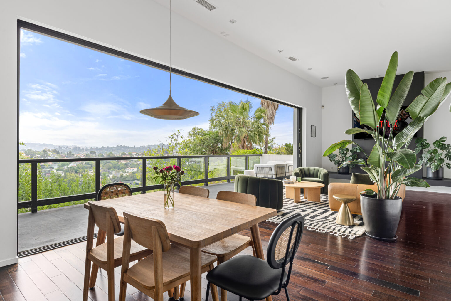 Dining table with indoor plants, stylish LA real estate listing.