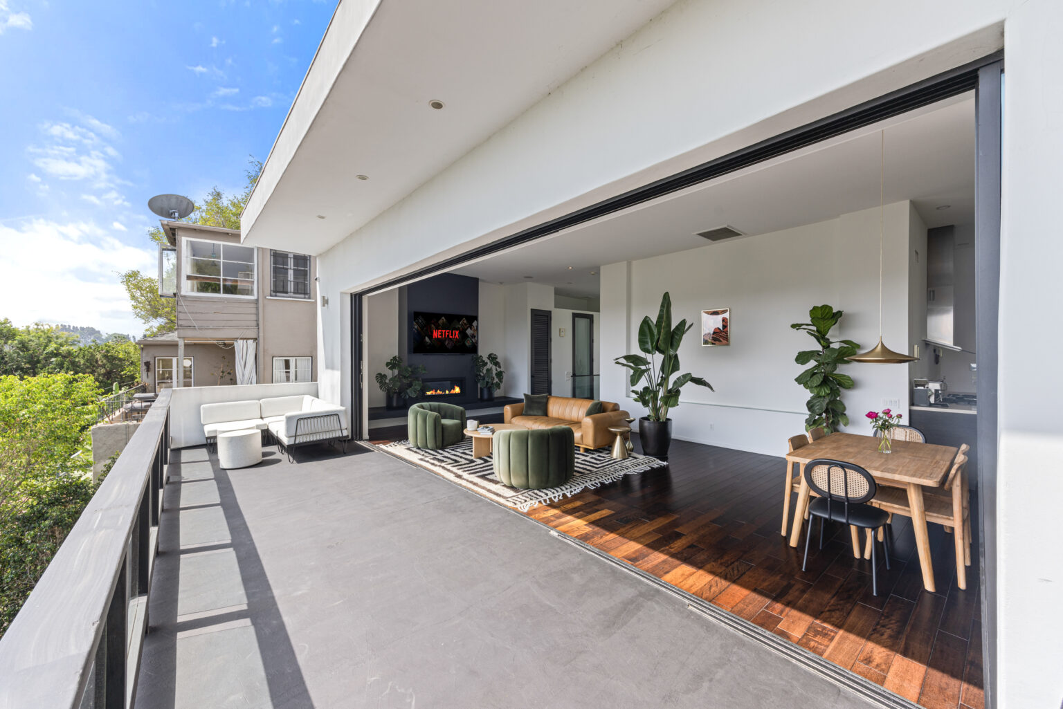 Indoor-outdoor lounge with patio doors open, modern SFV real estate.
