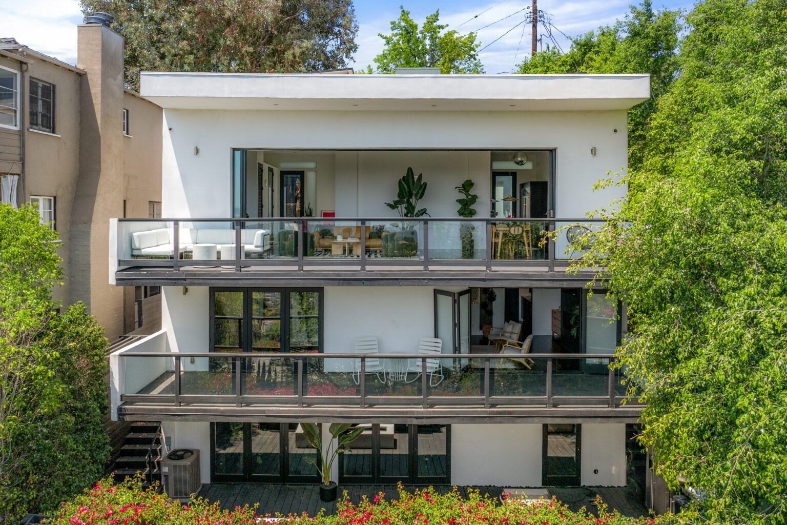 Three-story modern home with open balconies, photographed in Los Angeles.