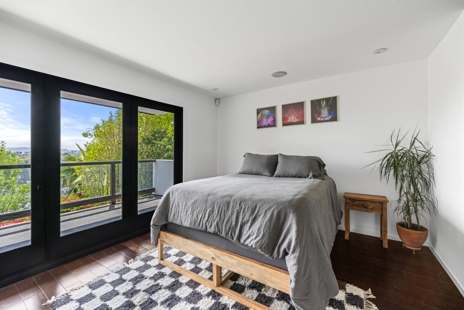 Primary bedroom with balcony and city views in LA.