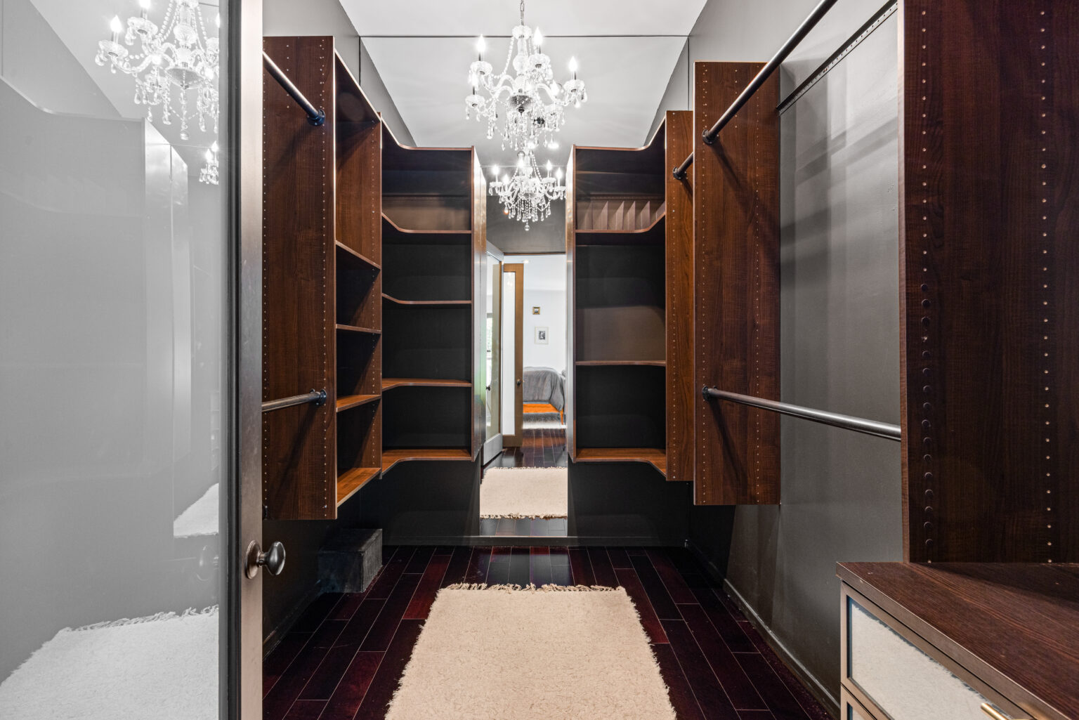 Walk-in closet with dark wood shelving in Los Angeles home.