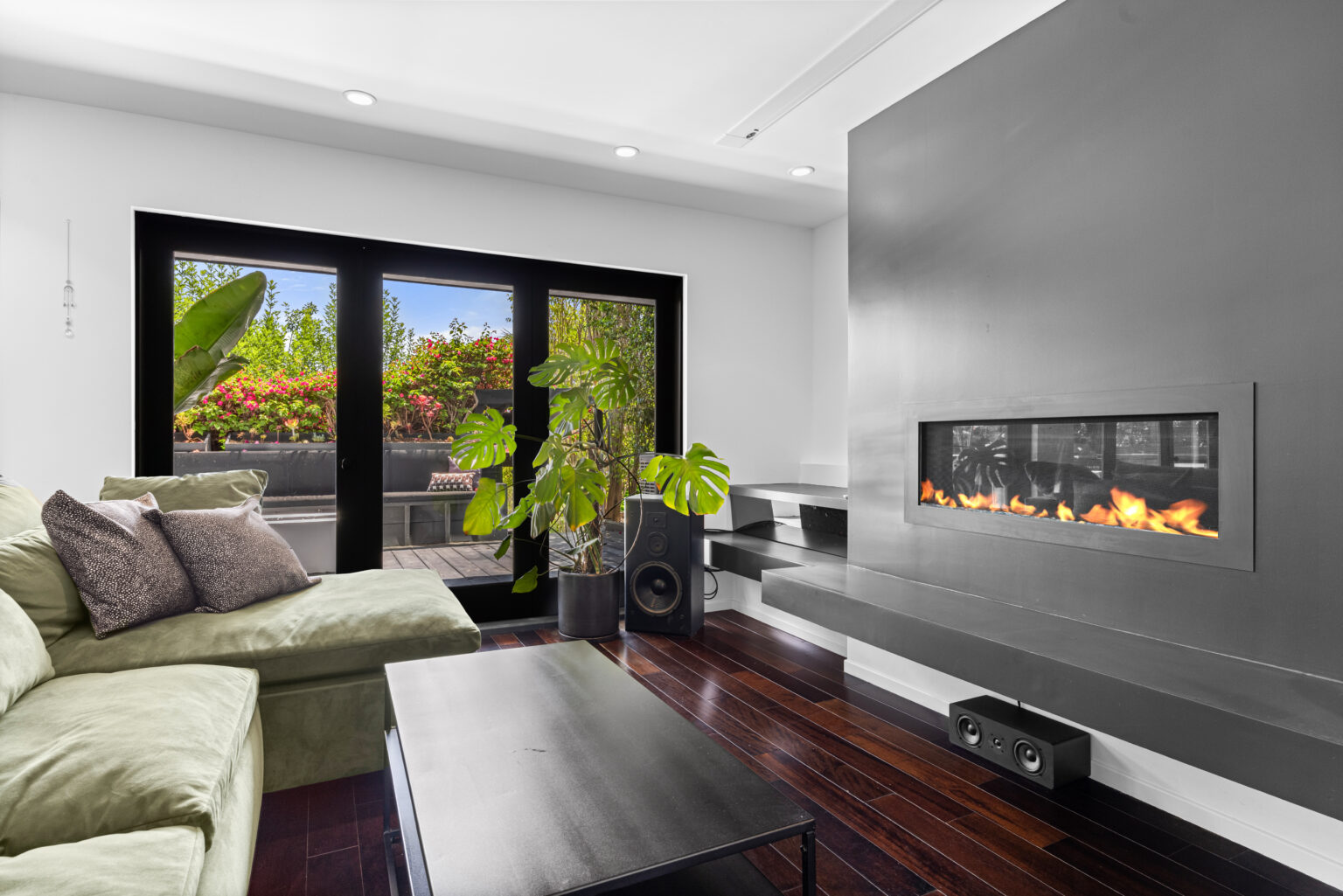 Contemporary living room with fireplace, green sofa, and sliding doors to patio