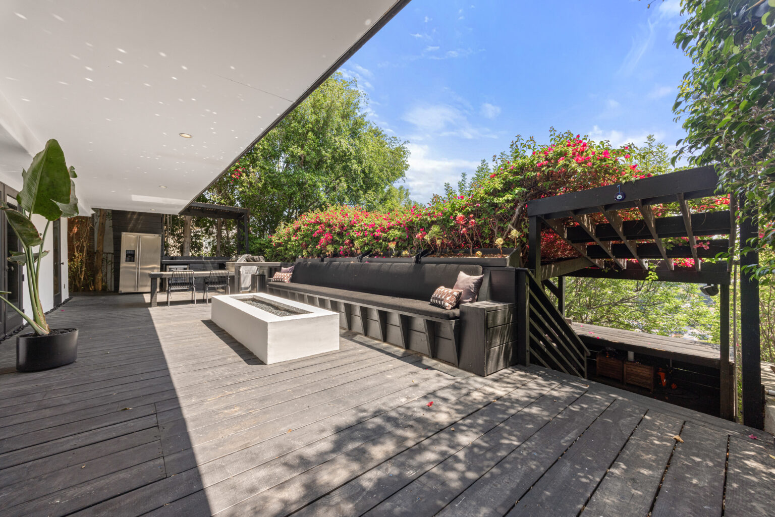 Another outdoor patio angle with seating and lush greenery