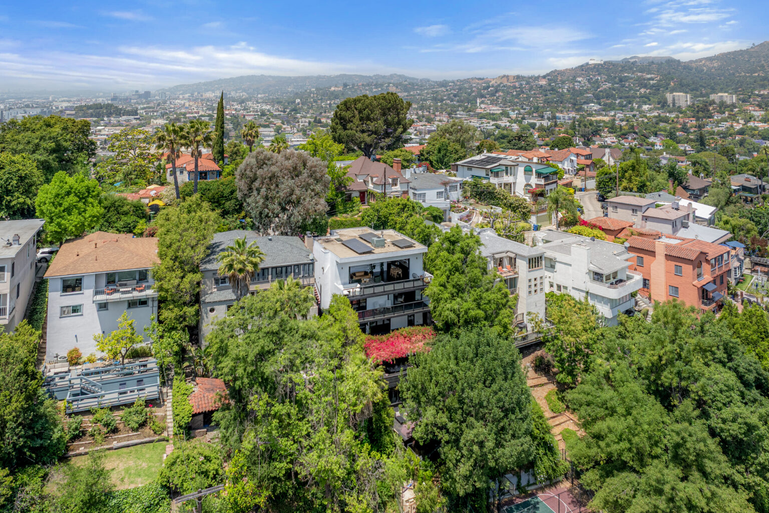 Neighborhood drone view with greenery, LA real estate.