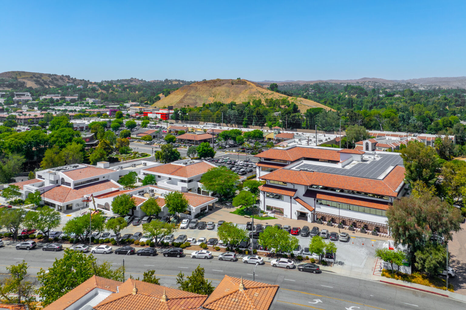 Drone view of retail center and green hills