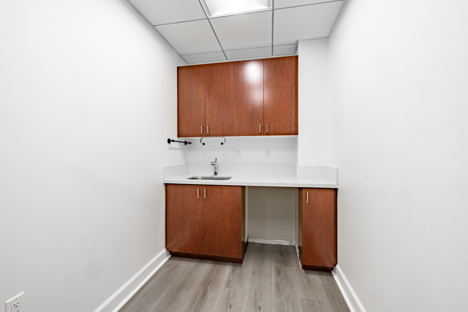 Small kitchenette with cabinets and sink inside office space