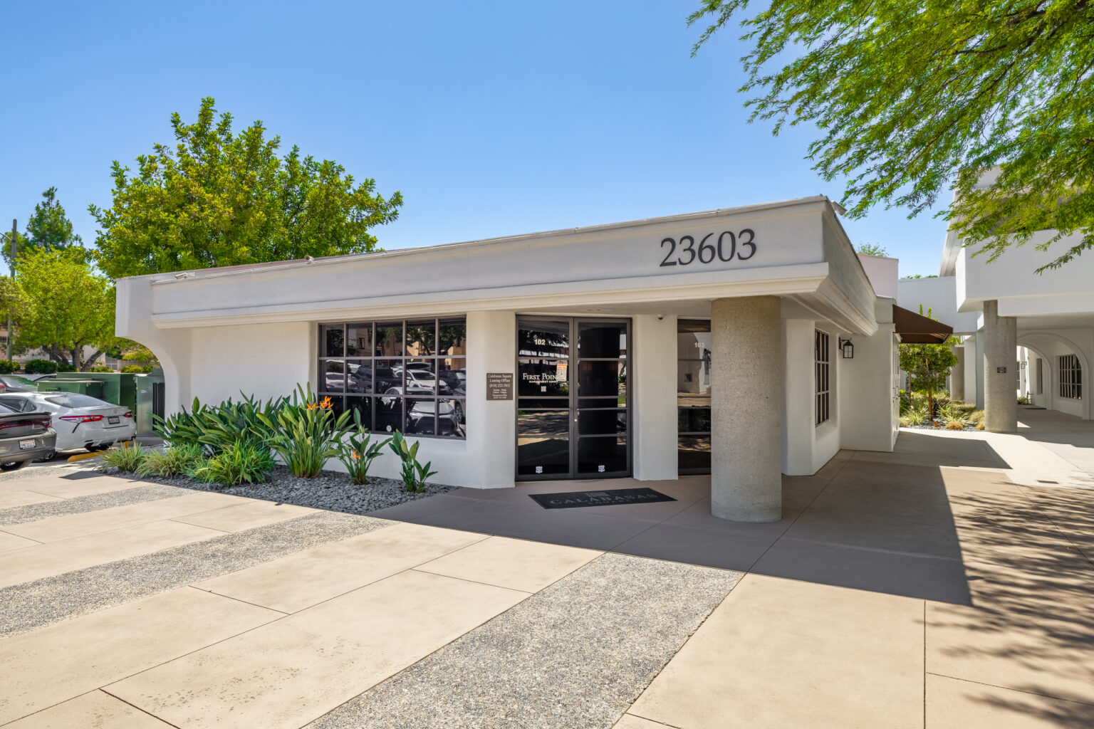 Single-story office entrance with address sign