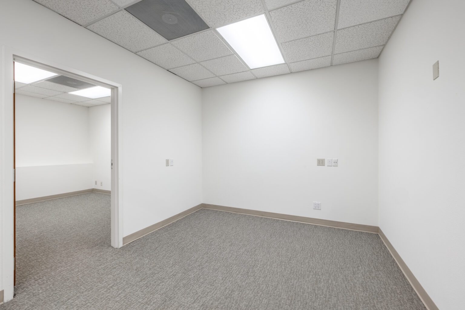 Small white office room with drop ceiling tiles
