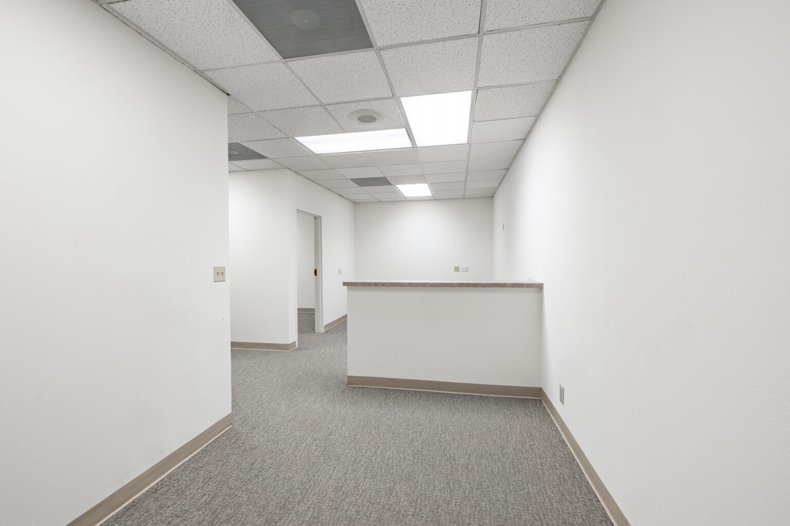 Another empty carpeted office with white walls and window