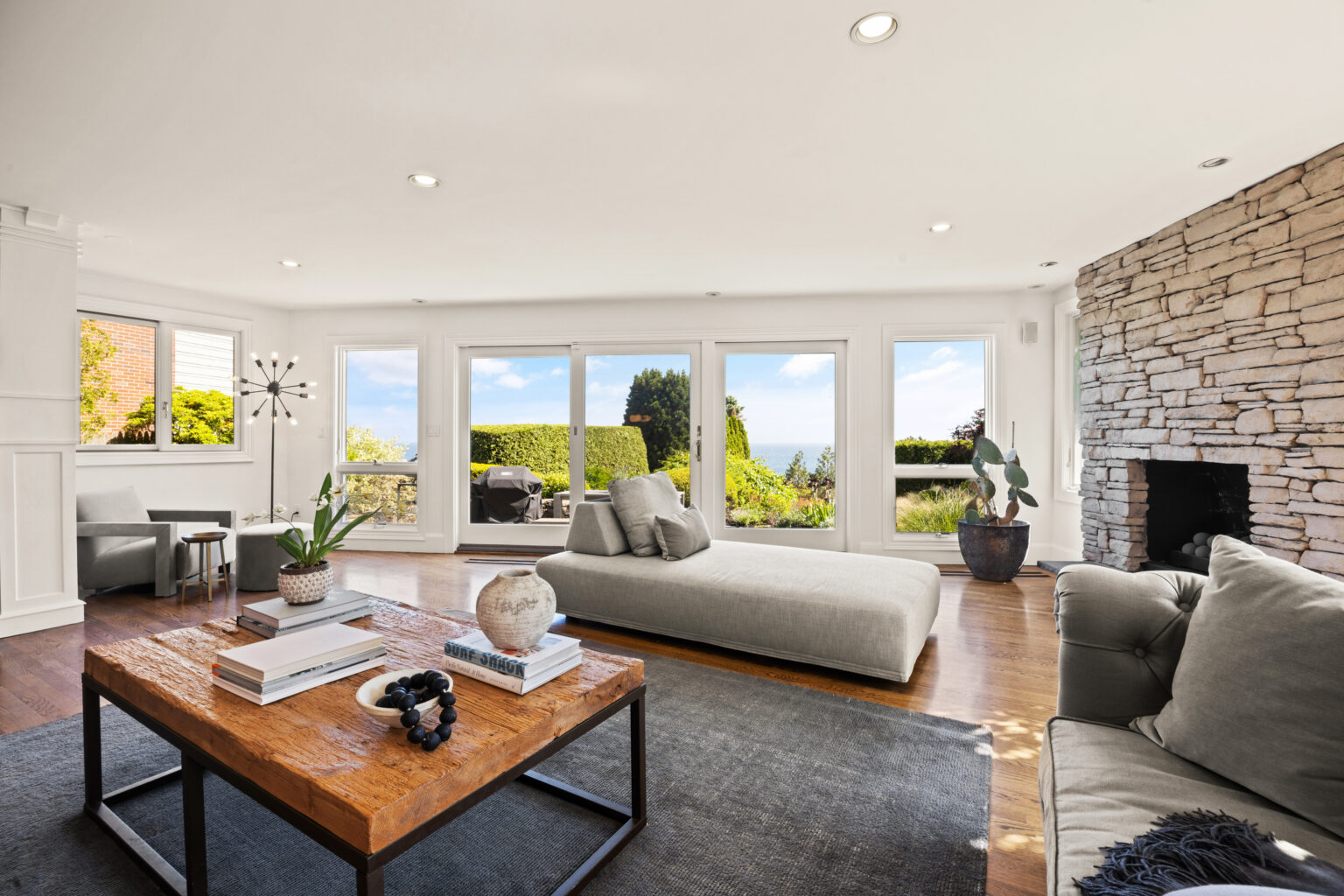Living room with sofa, armchairs, and large window