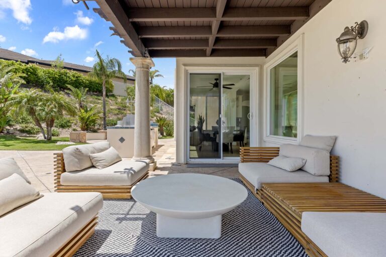 Covered patio lounge area with seating and outdoor rug