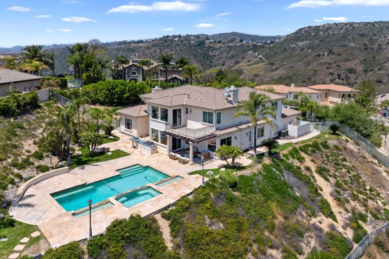 Rear exterior of house with pool and hillside backdrop in West Hills.