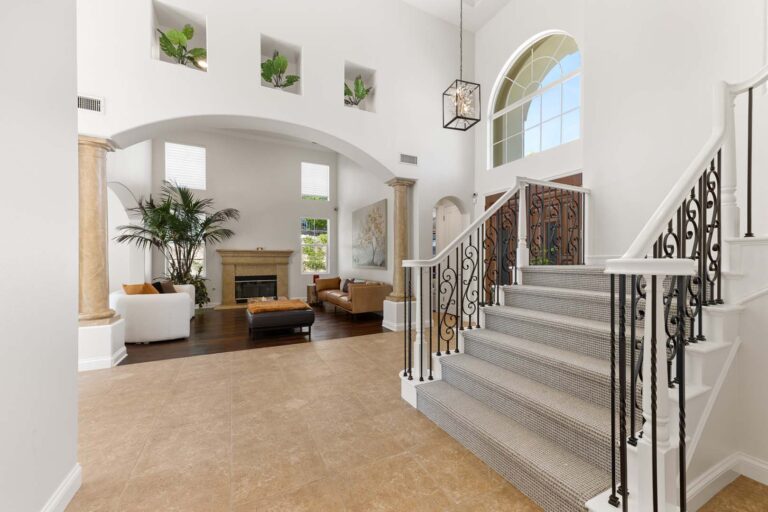 Large living space with fireplace, archway, and view to staircase