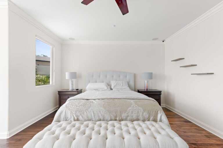 White bedroom with tufted bed and minimal decor