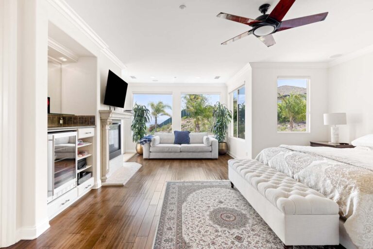 Bedroom with ceiling fan, bed, and large windows