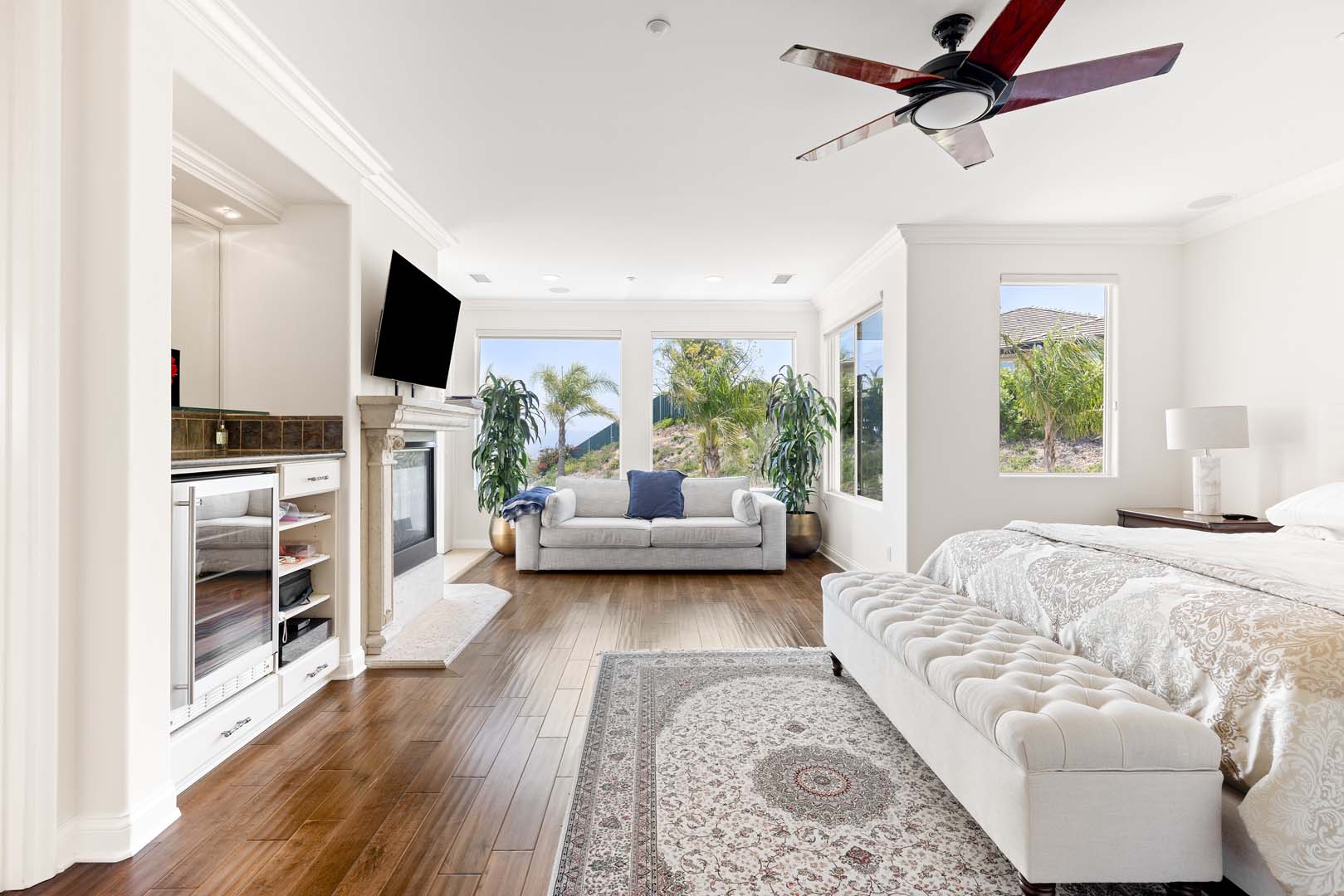 Bedroom with ceiling fan, bed, and large windows