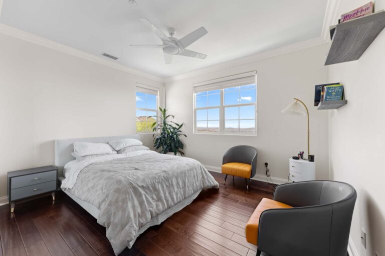 Guest bedroom with bed, ceiling fan, and window