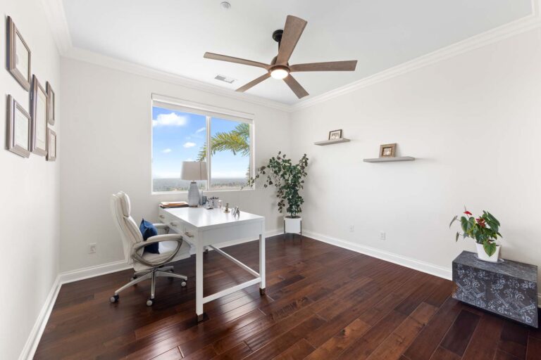 Bright office or study room with ceiling fan and desk
