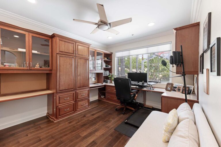 Home office with built-in desk and large window