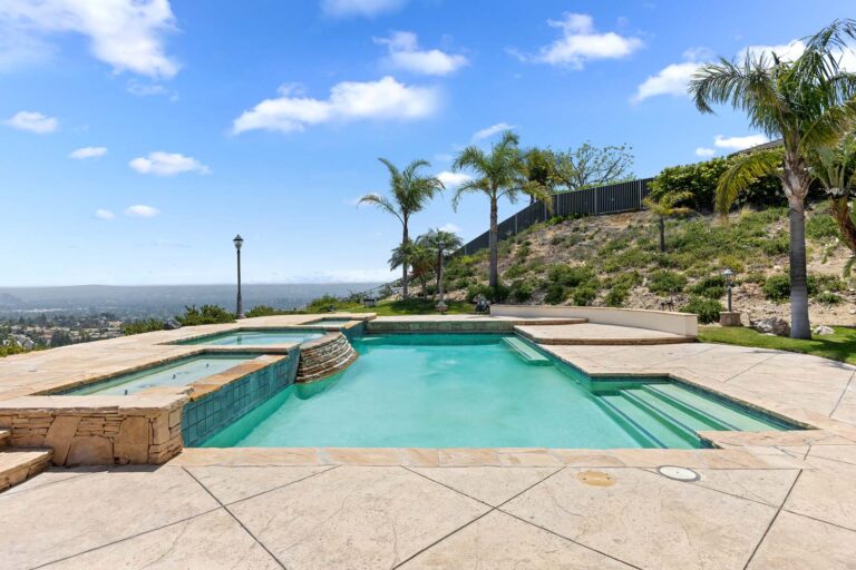Pool and hot tub surrounded by stone decking